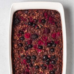Chocolate Banana Baked Oatmeal with Berries in white baking dish