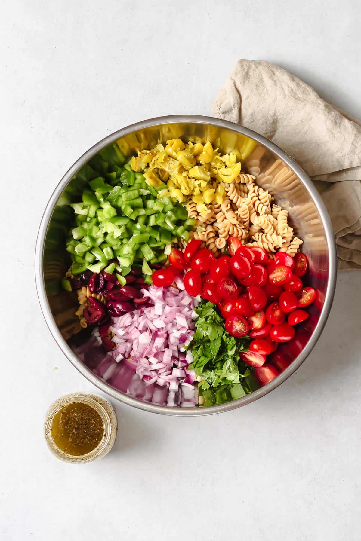 Pasta salad ingredients in stainless steel mixing bowl