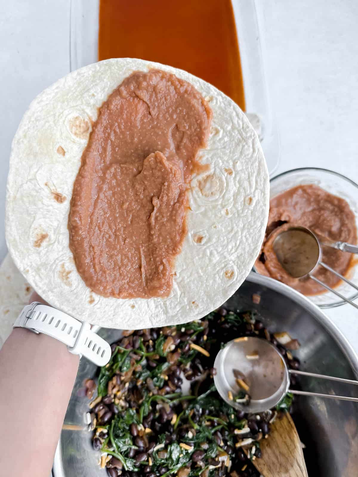 Flour tortilla with vegetarian refried beans spread down the center.