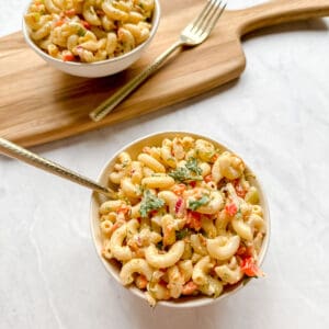 Vegan macaroni salad in a white bowl and a golden fork