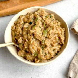 A bowl of zucchini oatmeal with a spoon in it.