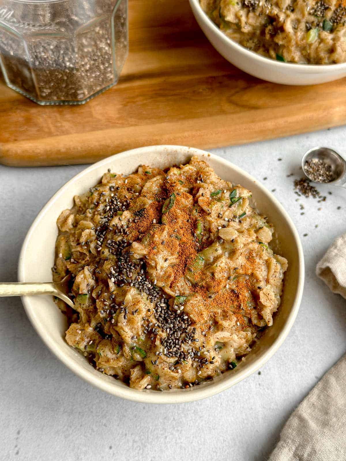 Bowl of zucchini oatmeal topped with chia seeds and cinnamon