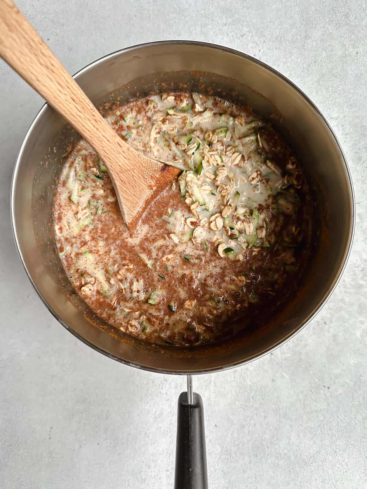 Ingredients mixed together in a stainless steel pot on a white background