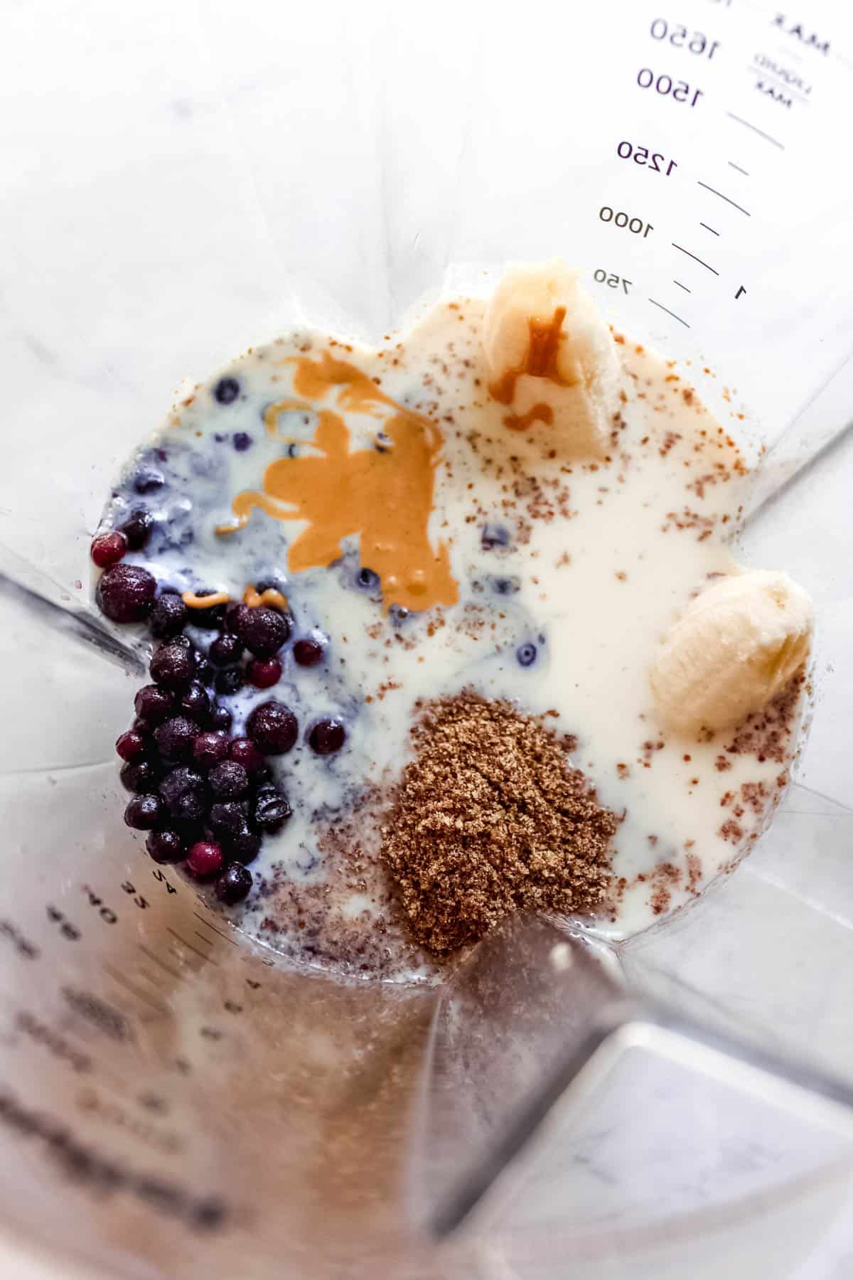 All of the smoothie ingredients in a blender, not yet blended.