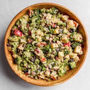 Vegan Broccoli Apple Salad served in a large brown ceramic bowl on a white background
