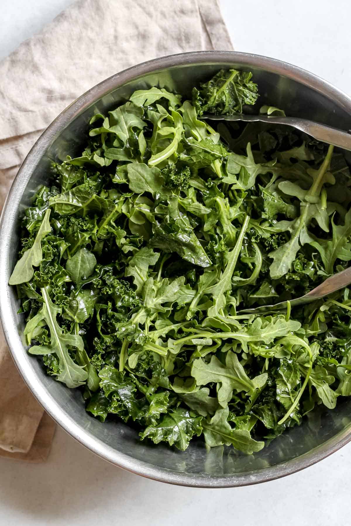 Kale and arugula in stainless steel mixing bowl.
